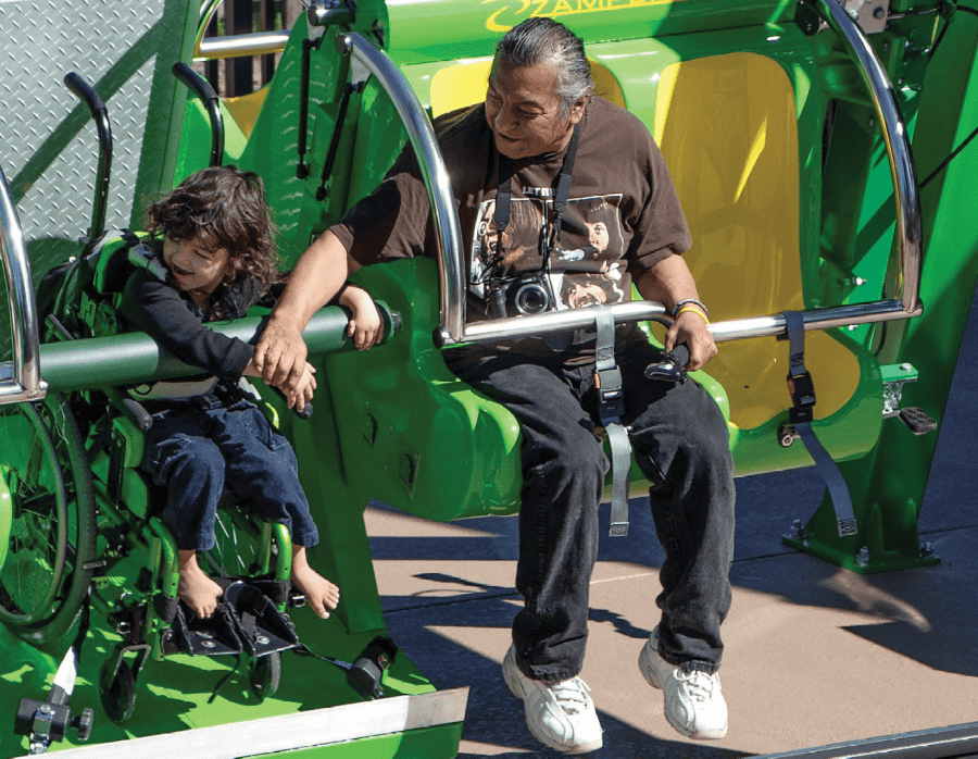 Child in wheelchair enjoys Zamperla Happy Swing at Give Kids The World